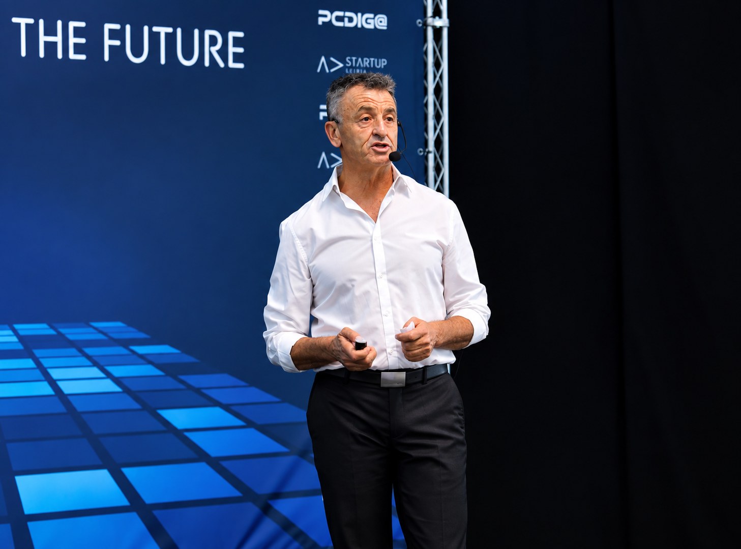 Britaldo Sousa, de camisa branca, de pé num evento diante de um painel azul com a inscrição THE FUTURE e o logótipo Startup Leiria